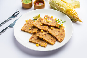 Sweet corn stuffed paratha or parotha served in a plate, Indian flatbread recipe made filling makai