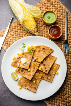 Sweet corn stuffed paratha or parotha served in a plate, Indian flatbread recipe made filling makai