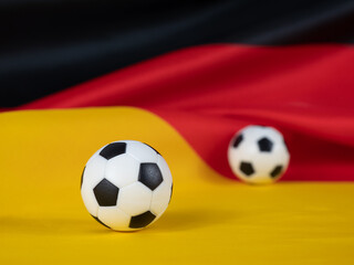 Fototapeta premium Soccer ball on the German flag. The ball against the background of the German flag.