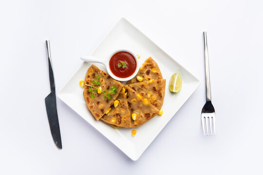 Sweet corn stuffed paratha or parotha served in a plate, Indian flatbread recipe made filling makai