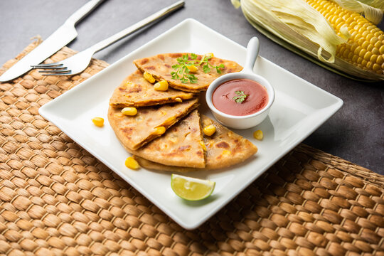 Sweet corn stuffed paratha or parotha served in a plate, Indian flatbread recipe made filling makai