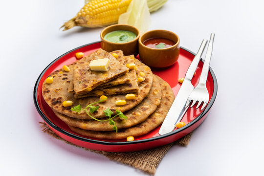 Sweet corn stuffed paratha or parotha served in a plate, Indian flatbread recipe made filling makai