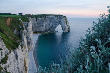 Panoramic landscape on the cliffs of Etretat at sunset. Natural amazing cliffs. Etretat, Normandy, France, La Manche or English Channel at sundown. Coast of the Pays de Caux, France