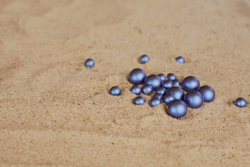 dark blue round pearls on the sand