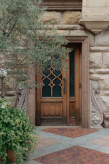 Fototapeta na wymiar Beautiful vintage wood doors in stone wall and olive tree