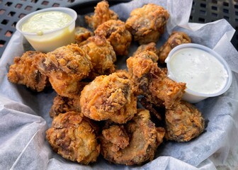 Fried mushroom appetizer in a basket with ranch and horseradish sauces