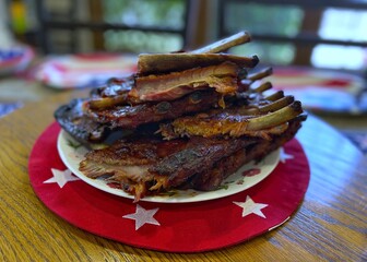 BBQ St. Louis ribs on a plate resting on a red and white placemat