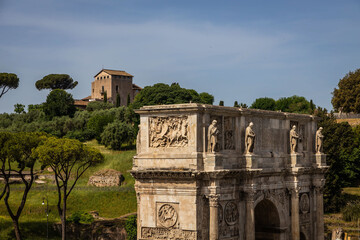 Fototapeta na wymiar The Arc of Constantine with a villa in the distance on the Palatine Hill in Rome, Italy.