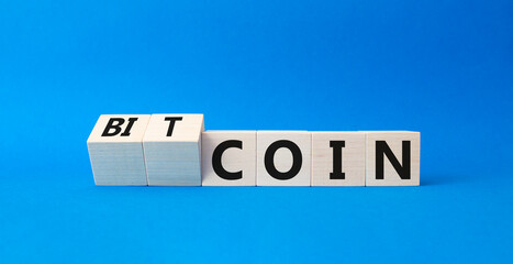 Bitcoin symbol. Turned wooden cubes with words Bitcoin and Coin. Beautiful blue background. Business and Bitcoin concept. Copy space