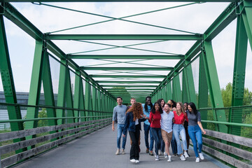 Group of young people crossing a bridge spending a day together outdoors