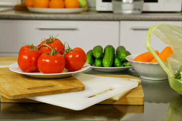 On the table are tomatoes, cucumbers, carrots, cheese, bread in a basket, herbs, dill, green onions, a knife on the board
