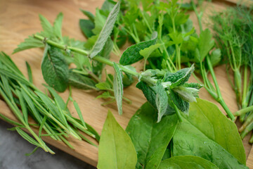 Various herbs picked from the garden, getting ready for drying, on wooden background