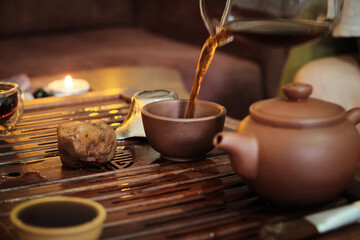 Brewing puerh tea. Traditional chinese tea ceremony. Tea pouring from teapot to glass cup on a tea...