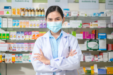 Portrait of female pharmacist wearing face mask in a modern pharmacy drugstore.