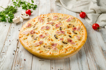Pizza with ham and mushrooms on white wooden table