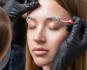 The make-up artist does Long-lasting styling of the eyebrows of the eyebrows and will color the...