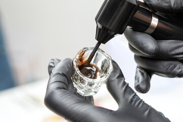 Long-lasting styling of the eyebrows procedure.Makeup artist mixes paint with an oxidizer.  Eyebrow...