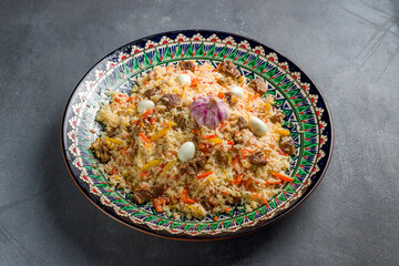pilaf with beef, eggs, carrot on beautiful uzbek plate