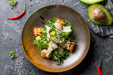 Salad Arugula with shrimps and avocado with parmesan on grey table top view