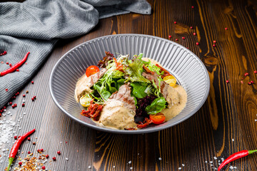 Steak salad with beef and mix salad on wooden table