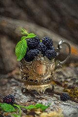 Blackberries in an old silver cup, vintage style. Soft, selective focus.