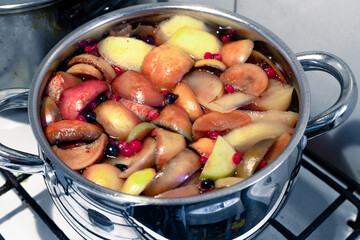 Freshly brewed fruit compote in a saucepan close-up - obrazy, fototapety, plakaty