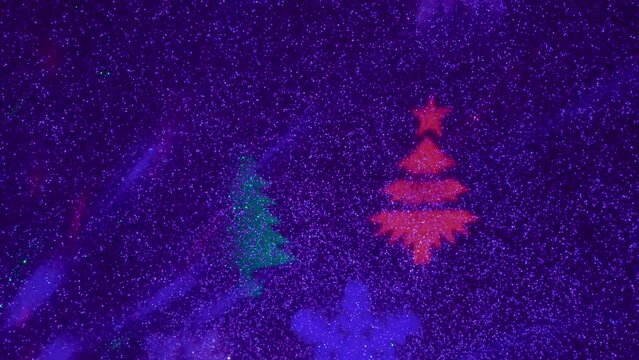 A carousel of light beams of different colors is set against a constantly flashing background that changes colors. Flying colored silhouettes of Christmas trees and snowflakes.