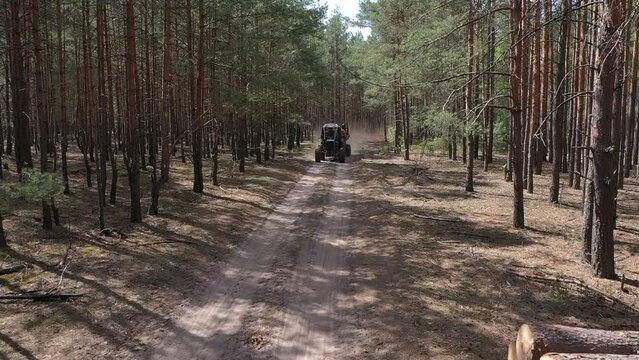 Crane forwarder machine during clearing of forested land. Wheeled harvester transports raw timber from felling site out. Harvesters, Forest Logging machines. Forestry forwarder on deforestation.
