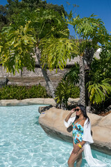 Mulher a passeio em frente a lindos coqueiros e piscinas de parque aquático, localizado em Caldas...