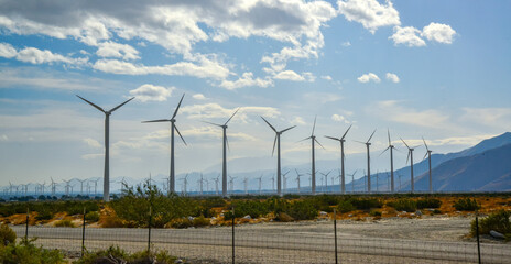 View of wind turbines generating electricity. Huge array of gigantic wind turbines spreading over the desert in Palm Springs wind farm, California