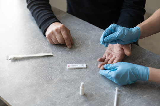 Nurse Performing A Coronavirus Pcr Test On An Elderly Man In His Home