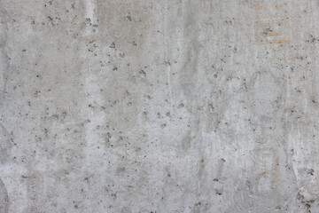 Texture and background of a gray concrete wall with potholes and scratches.