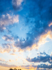 sunlit gray clouds in dark blue sky at sunset - obrazy, fototapety, plakaty