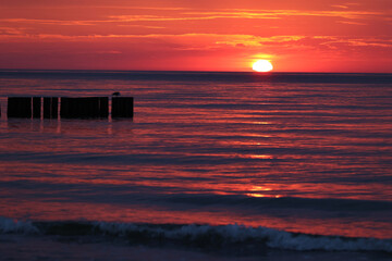 Czerwony zachód słońca nad morzem i czerwona woda. 