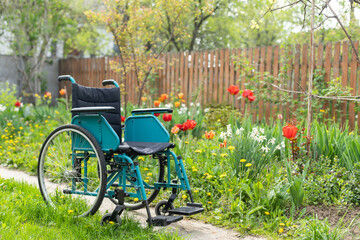 Fototapeta na wymiar Empty wheelchair parked near the house