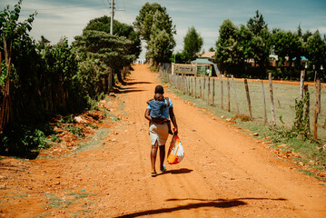A young African mother walks with her child on her shoulder. Challenging life and motherhood in Africa. Childcare in Kenya, illustration photo
