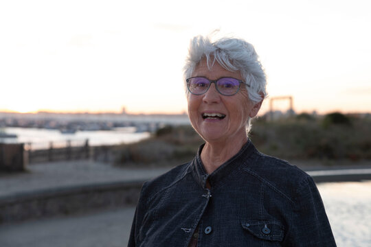 Portrait Of An Elderly Woman By The Sea In Brittany Under A Sunset