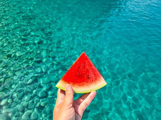 Bright red watermelon on blue sea background.
