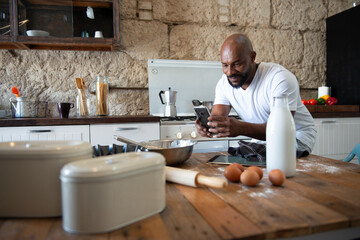 African man taking a photo of the food he is cooking in the kitchen of his house