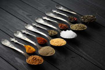 Colorful various herbs and spices for cooking on dark wooden rustic background