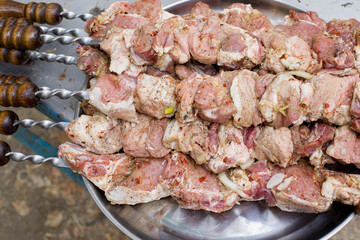 Raw pork shashlik on a metal tray, shish kebab in nature