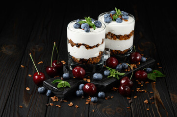 Homemade layered dessert with fresh blueberry, cherry, cream cheese or yogurt, granola.