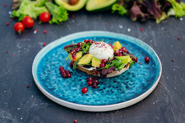 Whole wheat toasted bread with avocado, poached egg, soft cheese and mix salad. Healthy diet food breakfast