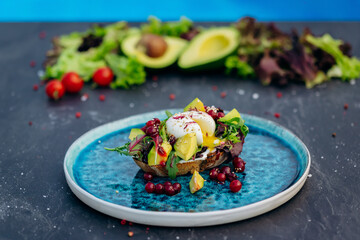 Whole wheat toasted bread with avocado, poached egg, soft cheese and mix salad. Healthy diet food breakfast