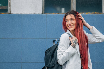 urban redhead girl with backpack on the street