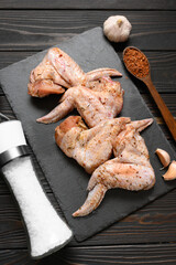 Marinated chicken wings on a rustic wooden background. © wolfhound911