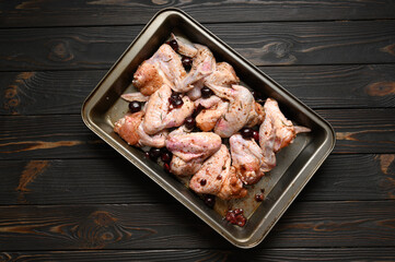 Marinated chicken wings with sweet cherry on a rustic wooden background