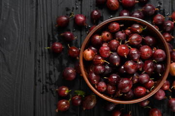 Ripe agrus or gooseberry on a dark wooden background.