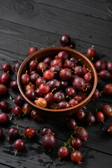 Ripe agrus or gooseberry on a dark wooden background.