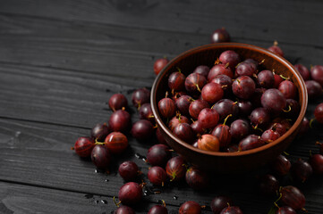 Ripe agrus or gooseberry on a dark wooden background.